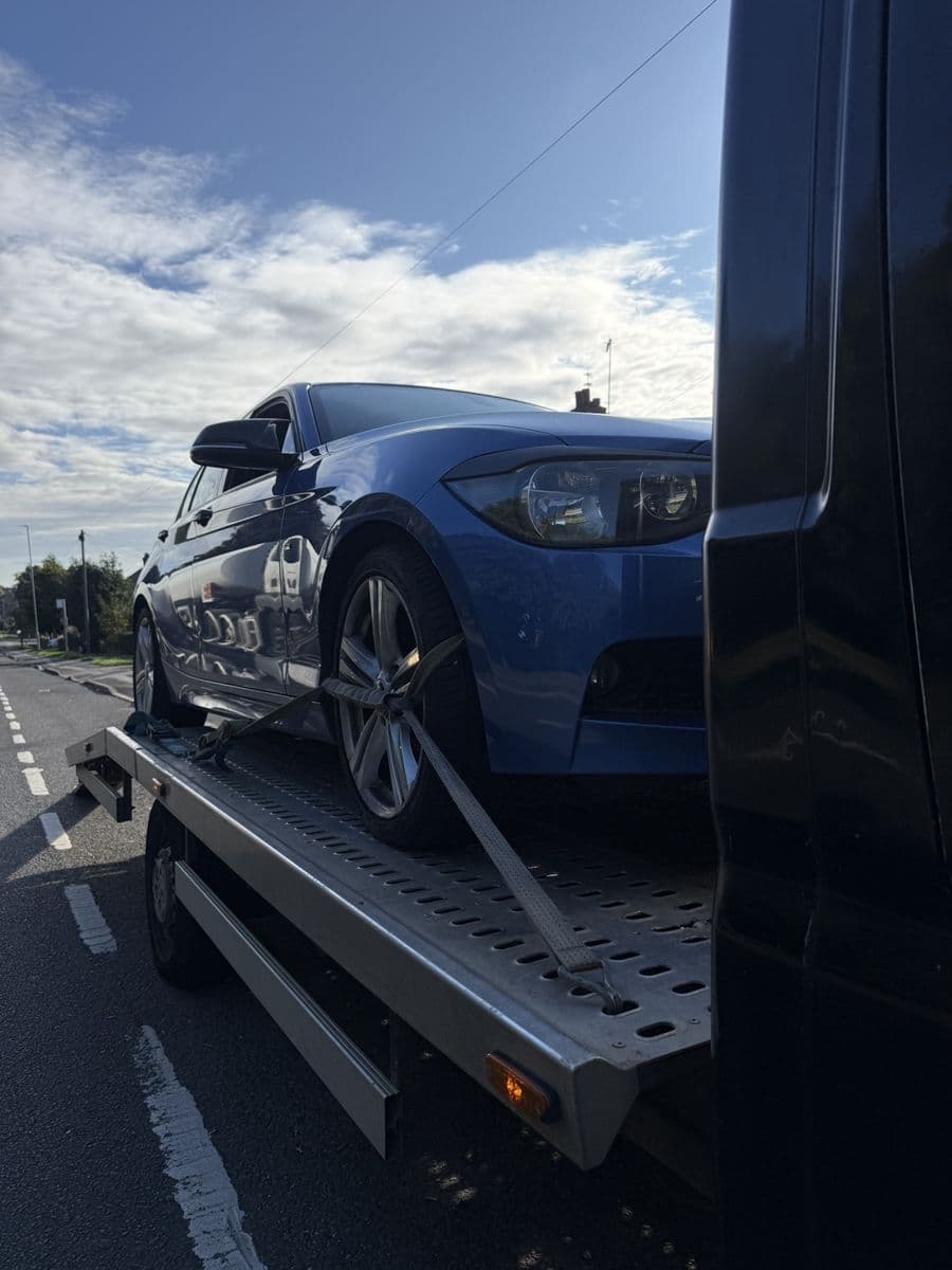 Blue BMW secured on a recovery vehicle